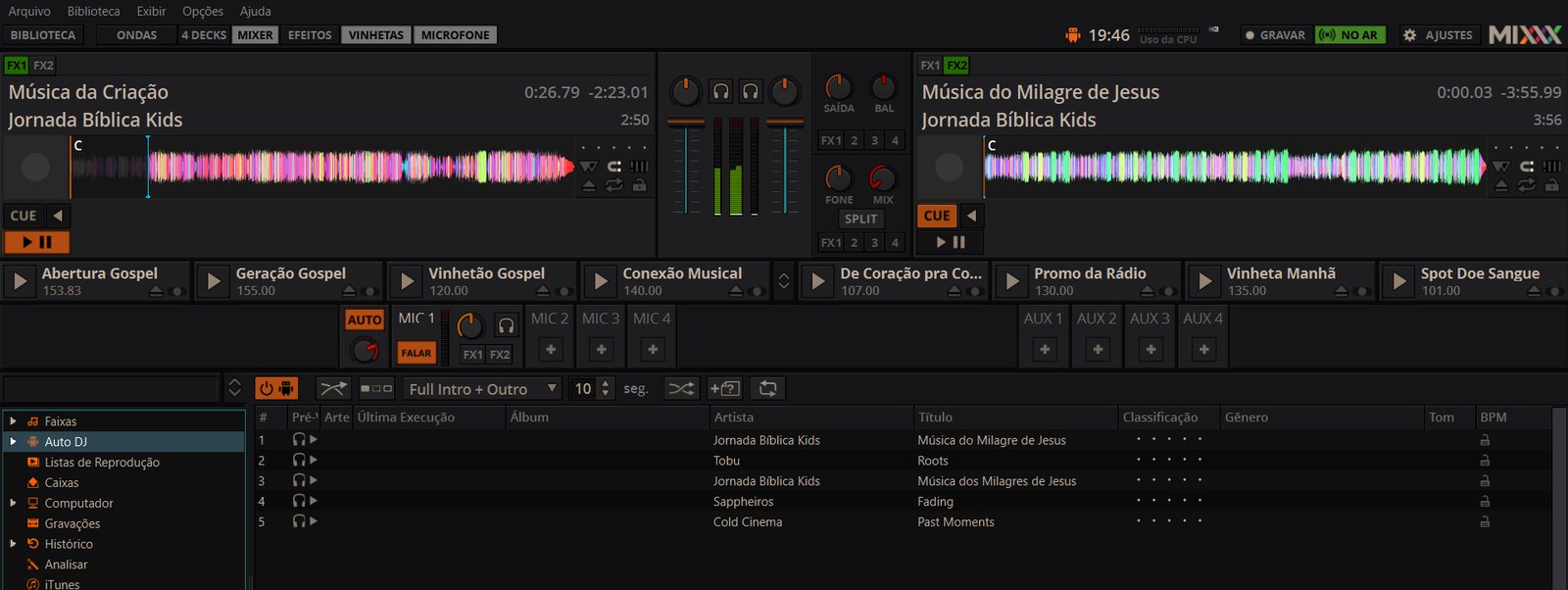 Tela do programa Mixxx em português, transmitindo: duas músicas carregadas, o botão NO AR aceso em verde, a fileira de vinhetas com nomes como Abertura Gospel e Vinhetão Gospel, o botão FALAR aceso em laranja e a fila do Auto DJ
